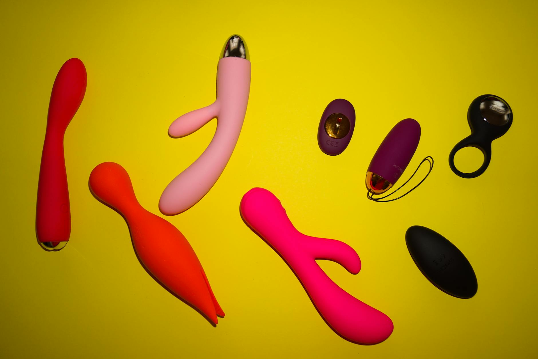Hands holding pastel silicone vibrators together, representing shared pleasure and intimacy