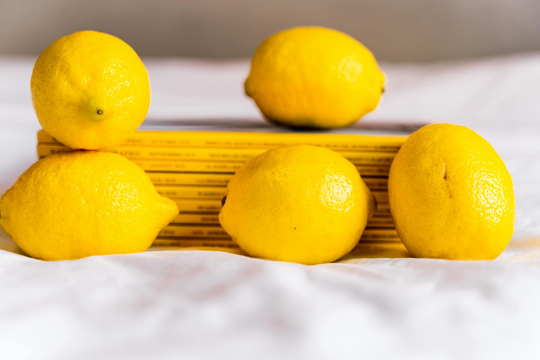 Ripe lemons on a bright yellow background, symbolizing the warmth and gentle reset a lemon clitoral vibrator can provide